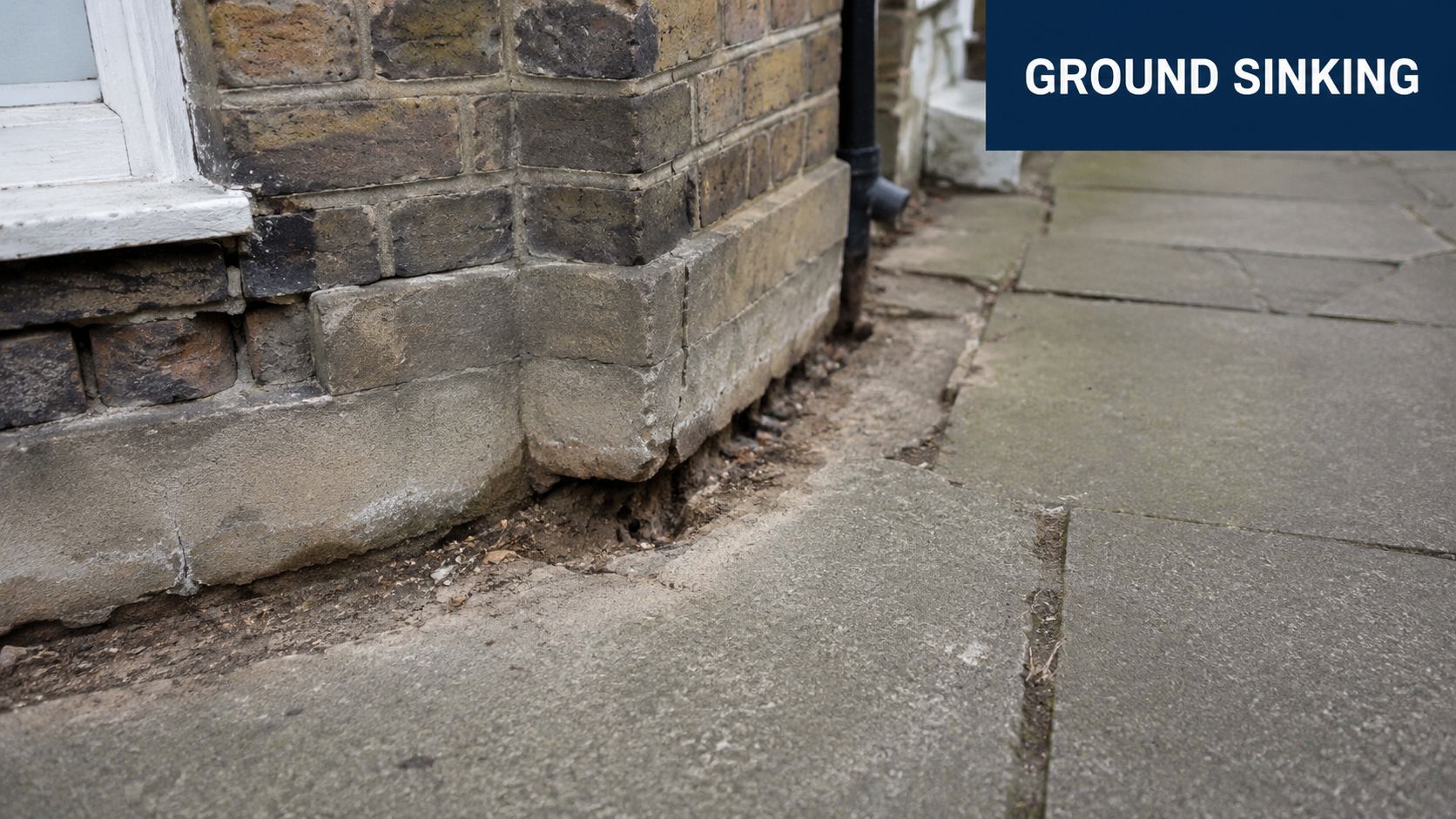 A close-up view of the corner of a building foundation showing soil erosion and ground sinking issues.